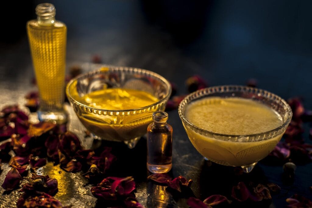 Close Up Shot Of Olive Oil And Rose Oil Face Mask In A Glass Bowl Along With Some Raw Ghee Essential Rose Oil And Some Carrier Oil Also Face Mask Used In Winter For Dry Skin